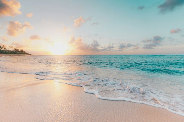 Soft surf on a pale beach at sunrise